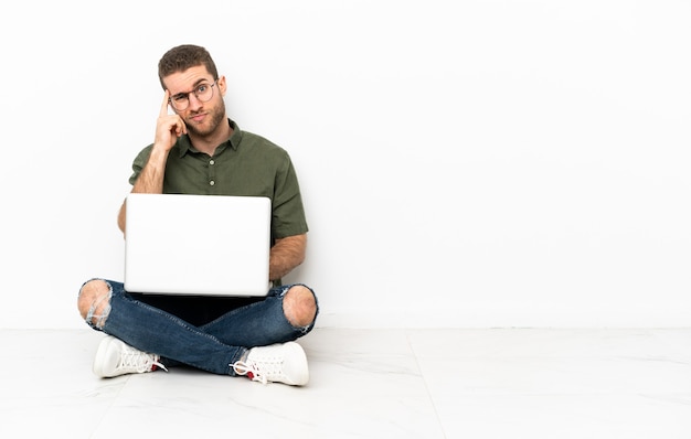 Young man sitting on the floor thinking an idea