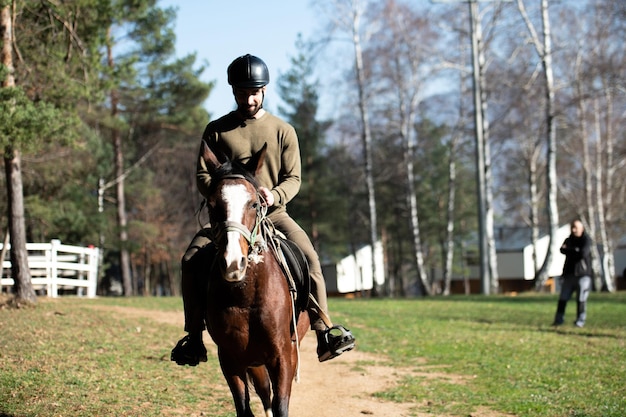 屋外で馬に座っている若い男