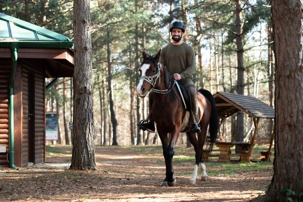 屋外で馬に座っている若い男