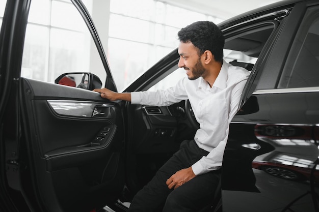 Young man sitting inside new car Smiling