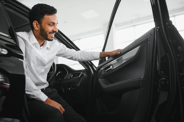 Young man sitting inside new car Smiling