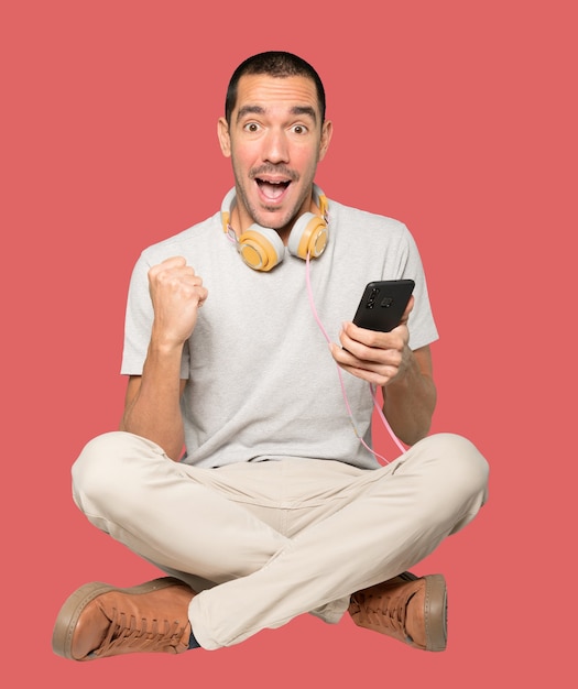 Young man in sitting position with a celebration gesture