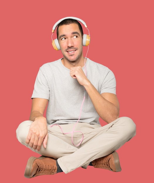 Young man in sitting position with a doubt gesture