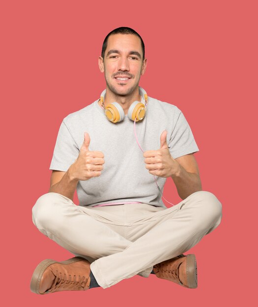 Young man in sitting position with a okay gesture