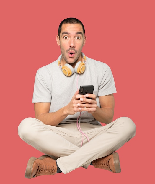 Young man in sitting position with a satisfaction gesture