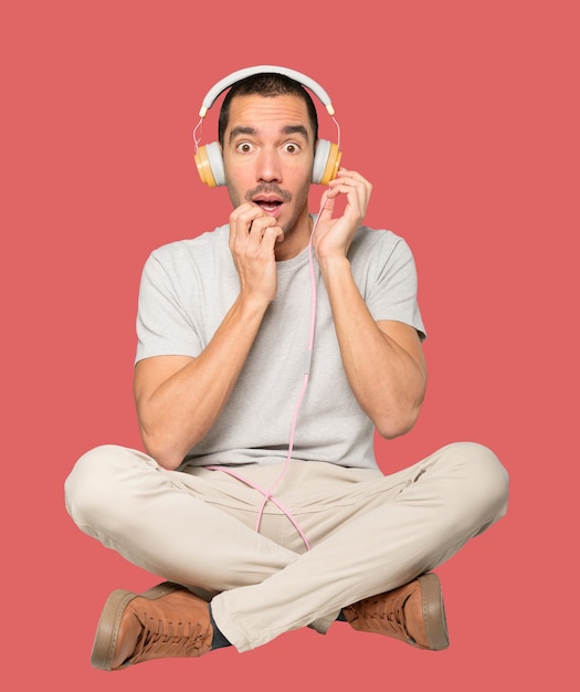 Young man in sitting position with a worry gesture