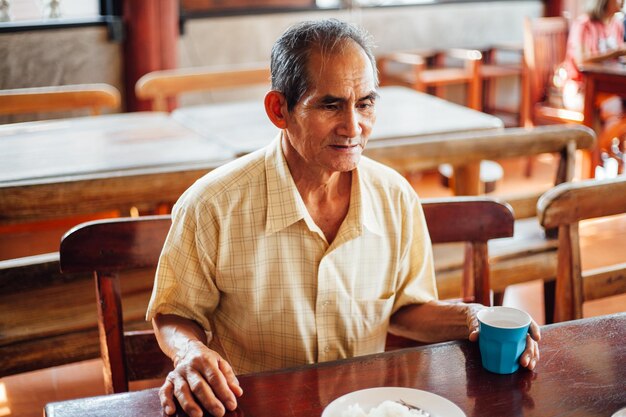 Photo young man sitting at restaurant