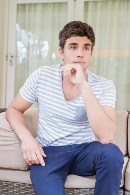 Young man sitting on sofa in living room