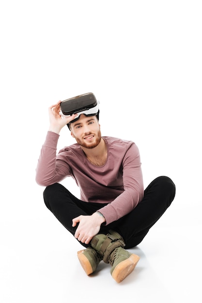 Young man sitting in studio and happily 