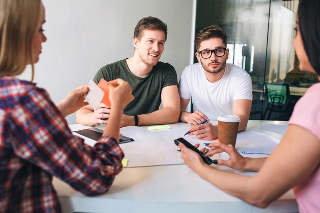 Photo young man sitting at table and look at brunette