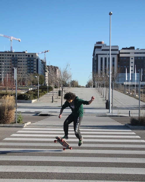 Young man skateboarding on road in city
