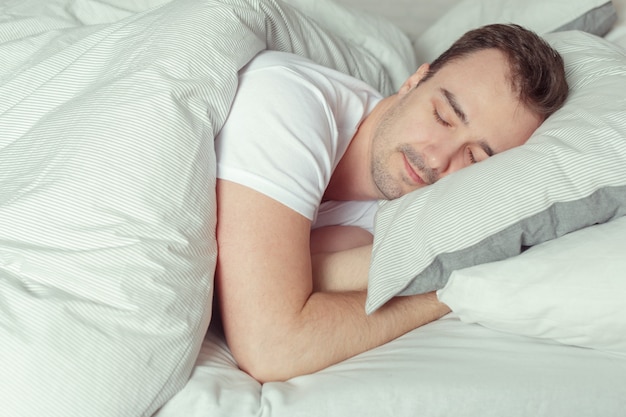 Young Man Sleeping On Bed In Bedroom