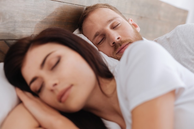 Foto giovane che dorme vicino a sua moglie e vede un sogno sulla loro lunga vita felice insieme