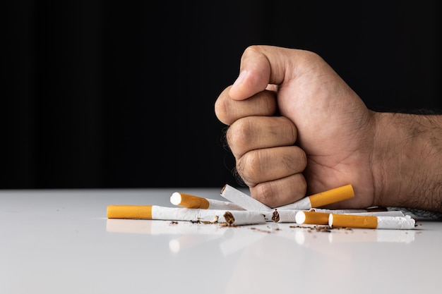 The young man smashed and smashed the cigarette with his hand. He wants to quit smoking for good health.