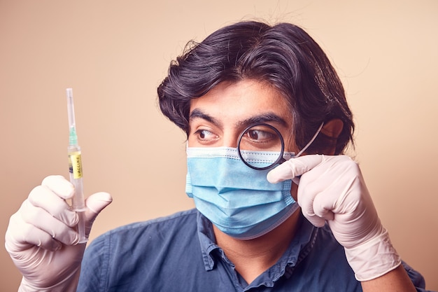 Foto un giovane sorride mentre indossa guanti di nitrile con una mascherina chirurgica sul viso