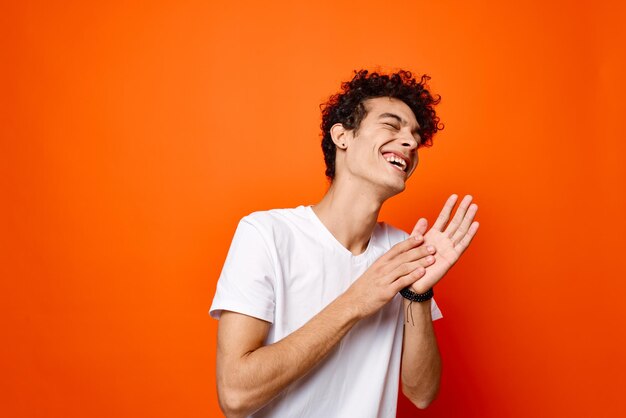 Young man smiling against orange background