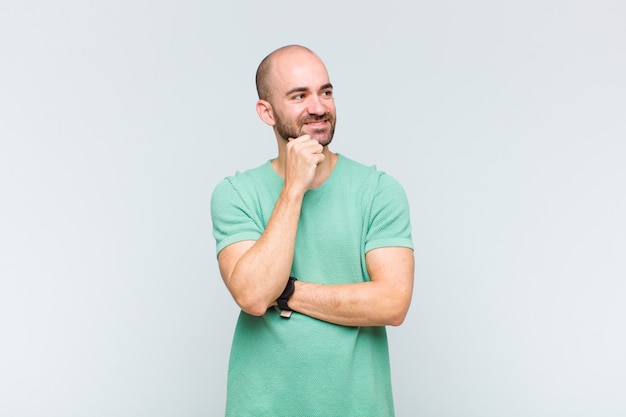 Young man smiling happily and daydreaming