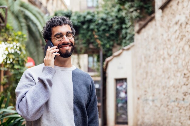 Young man smiling happy talking on the phone