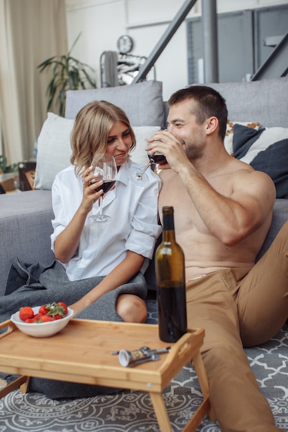 Giovane che sorride alla sua donna splendida mentre cenare romantico e bere vino
