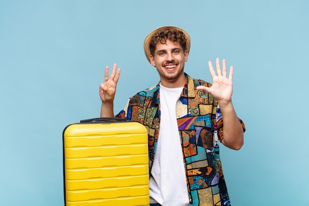 Young man smiling and looking friendly, showing number eight or eighth with hand forward, counting down. holidays concept