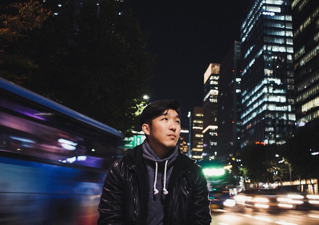 Photo young man smiling standing on road at night