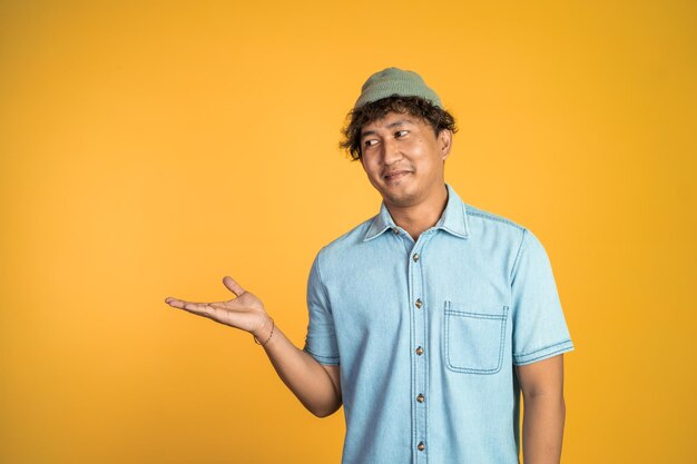 Young man smiling with both hands presenting something on isolated background