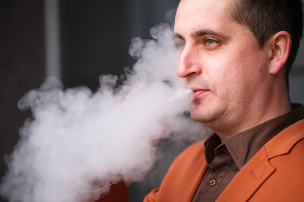 Young man smoking electronic cigarette 