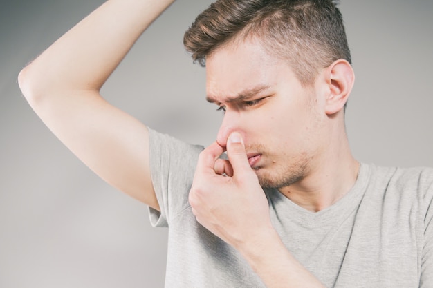 Young man sniffing an armpit