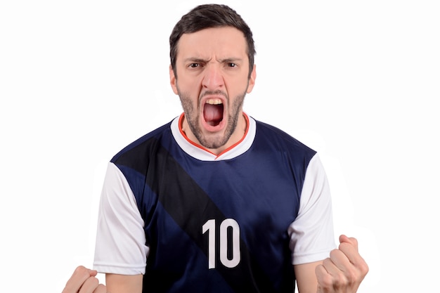 Foto giovane in uniforme di calcio di calcio che grida mentre la sua squadra vince.