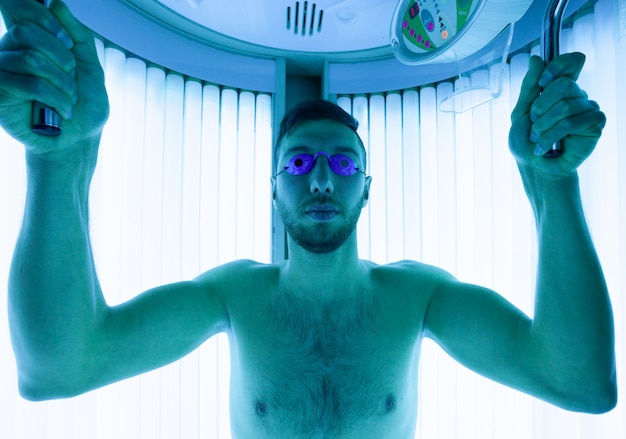 Young Man At Solarium In Beauty Salon.