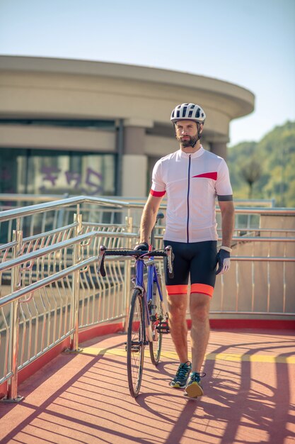 自転車で陽気な服の若い男