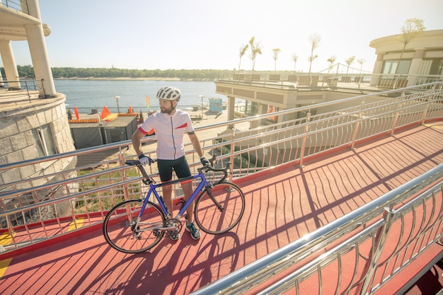 自転車で陽気な服の若い男