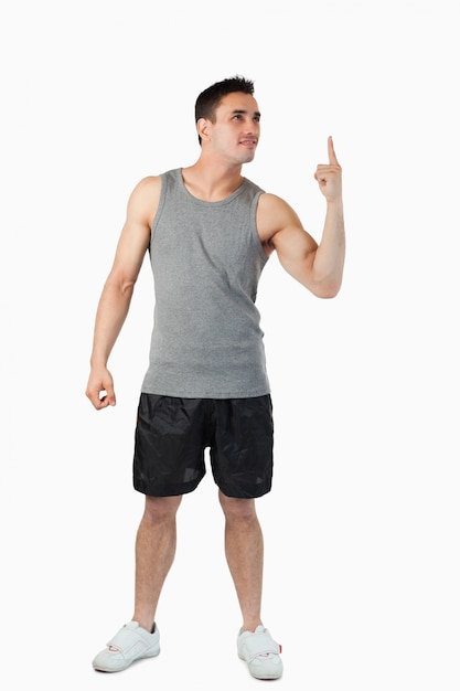 Young man in sports cloths pointing up