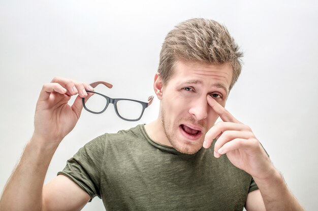 Young man stand and hold glasses in hand