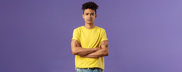 Young man standing against black background