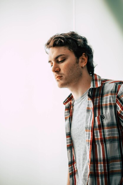 Photo young man standing against wall