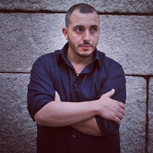 Photo young man standing against wall