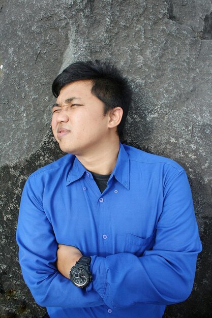 Photo young man standing against wall