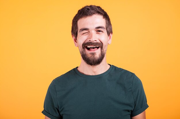 Photo young man standing against yellow background