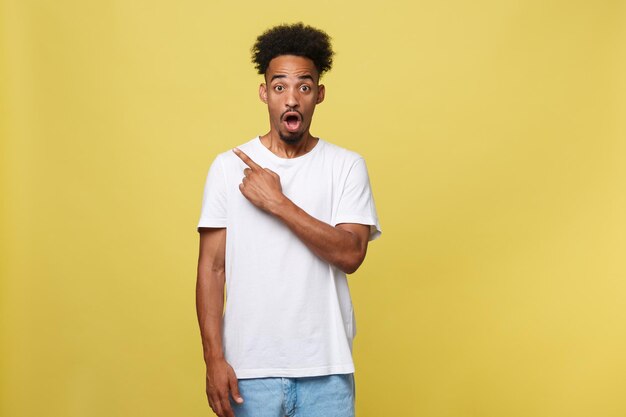young man standing against yellow background