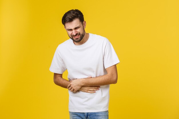 Young man standing against yellow background