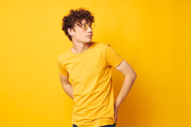 Young man standing against yellow background