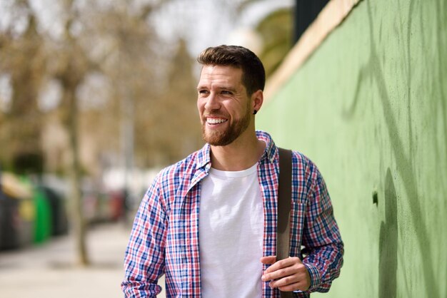 Young man standing by wall