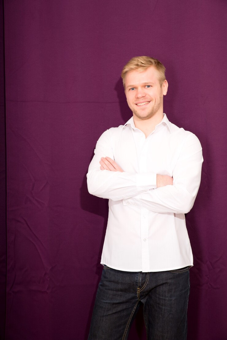 Photo young man standing in front of a closed curtain.
