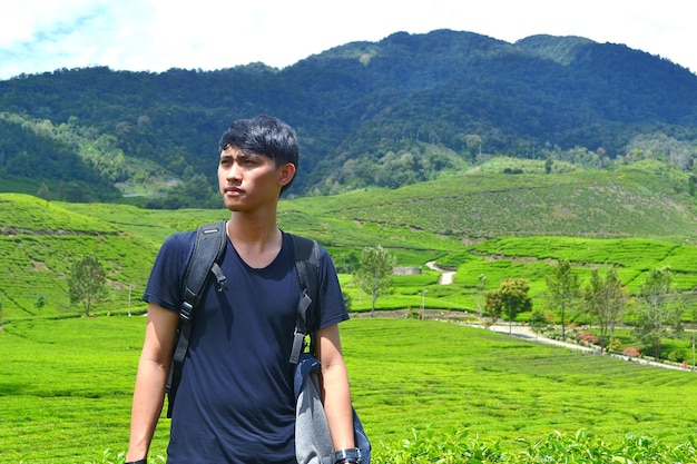 Foto giovane in piedi su un paesaggio verde