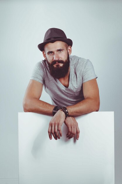 Young man standing in hat by blank whiteboard