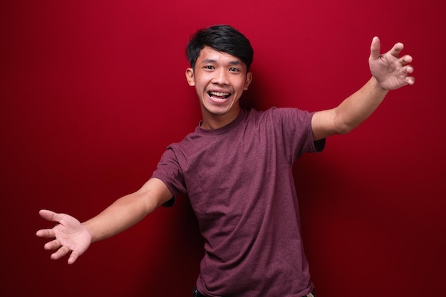 Young man standing over isolated red background very happy and excited doing winner gesture