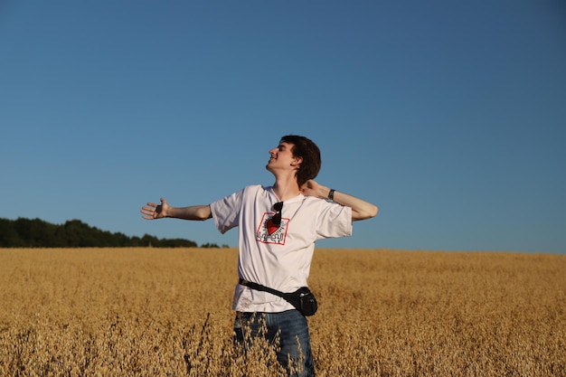 Young man standing in the oats field