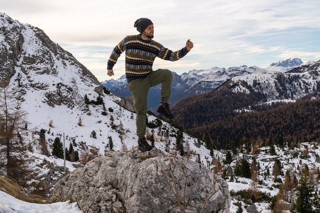 Young man standing on a rock in mountains