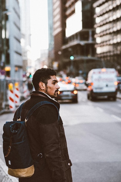 Photo young man standing on street in city